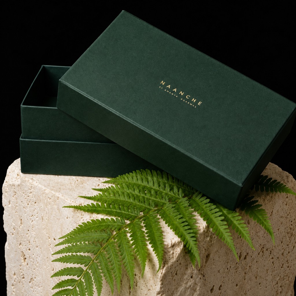 Deep green Naanche rigid presentation box with gold foil logo on travertine