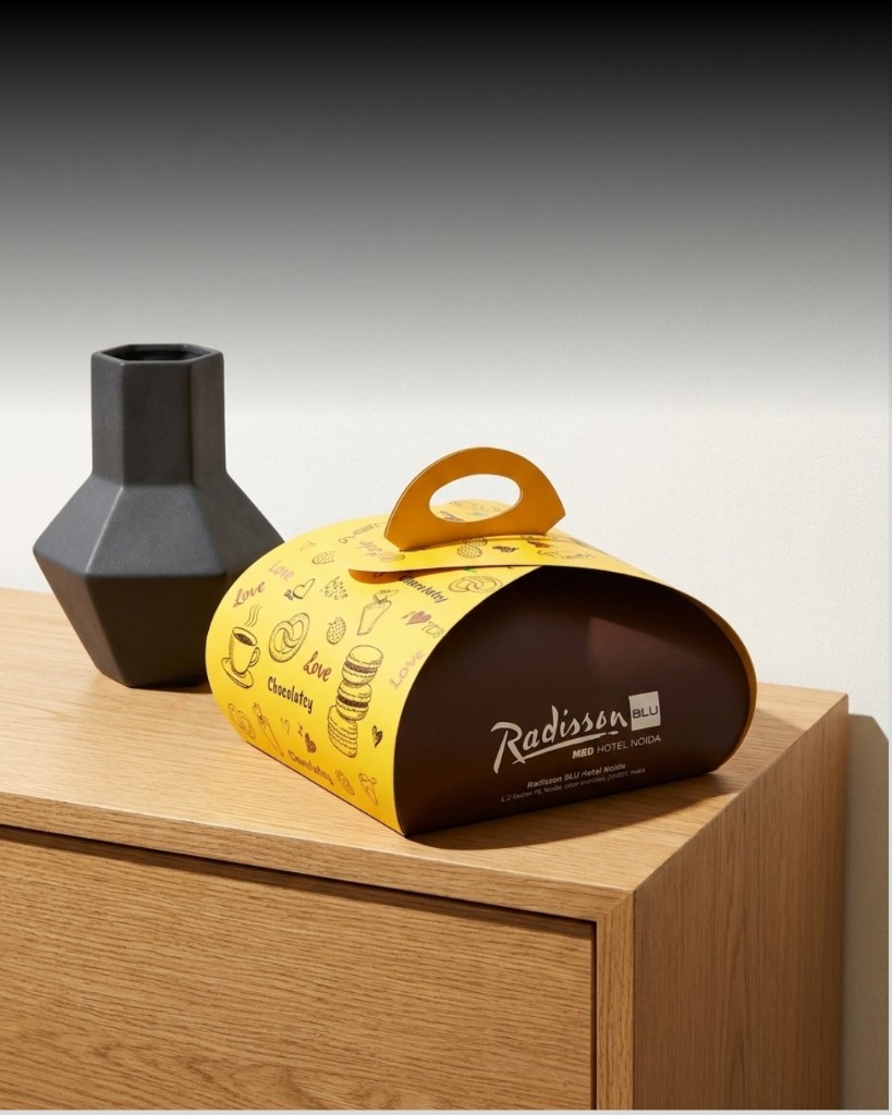 Yellow and brown Radisson BLU custom food packaging with illustrated pattern and carry handle
